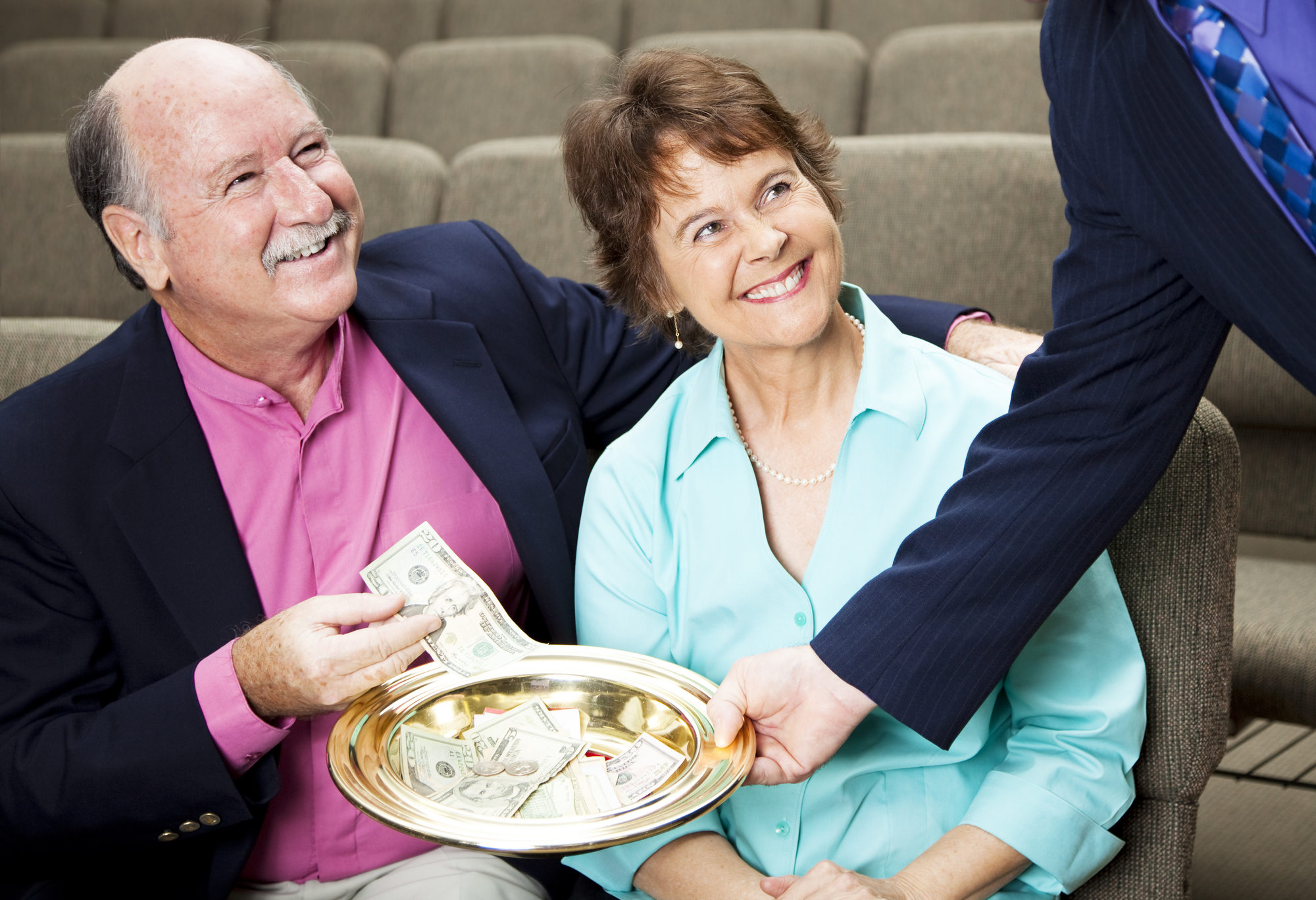 Couple,Placing,Money,In,A,Church,Collection,Plate.